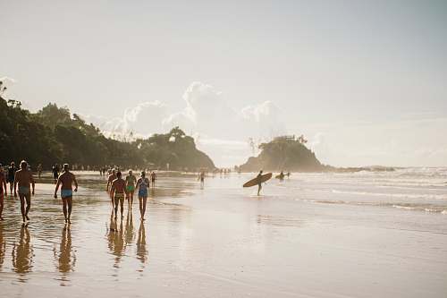 sea people walking along beach during daytime coast