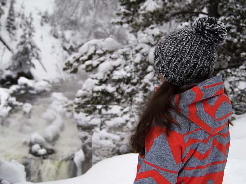hat woman standing on snow field near trees winter