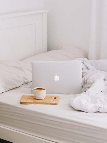 computer MacBook beside teacup with latte furniture