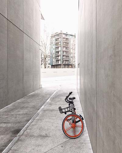 bike black and orange bicycle in between concrete walls italy