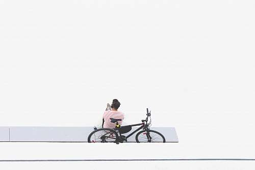 bike man sitting beside black mountain bike transportation