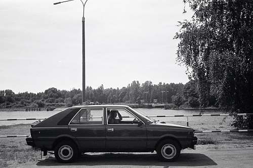 machine black 5 door hatchback parked on side of road wheel