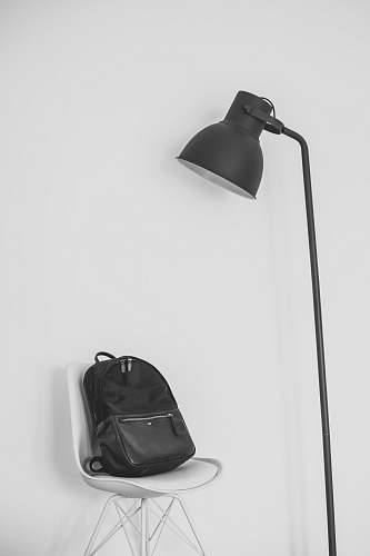 grey black lamp beside backpack on top of chair bag
