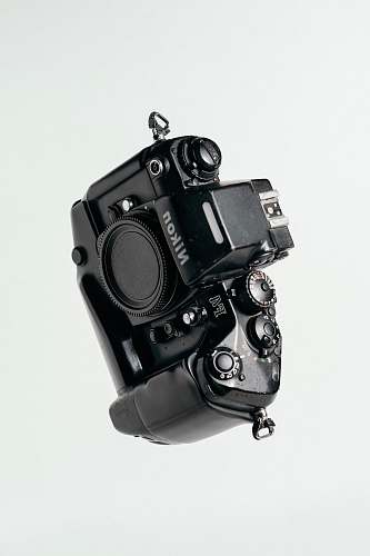 electronics black Nikon DSLR camera on whit surface camera