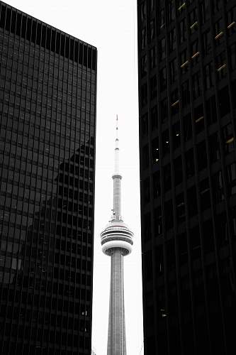 building CN tower in between glass skyscrapers toronto