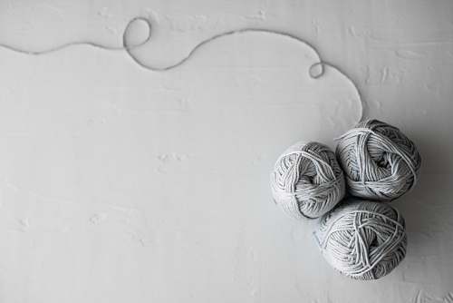 grey flat lay photography of three white yarn balls yarn