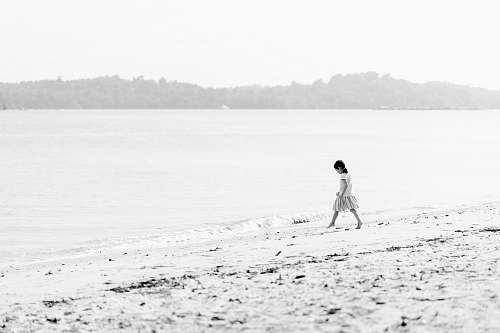 sand girl walking on beach during day time alone