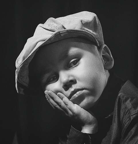 grey gray-scale photo of boy wearing cap apparel