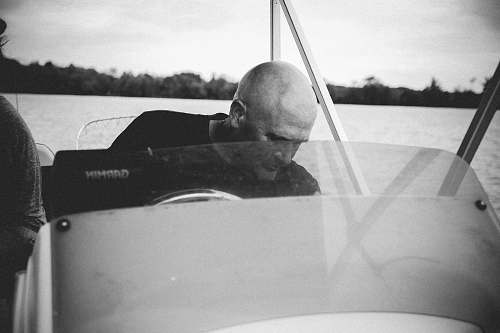 human grayscale of man riding on boat person
