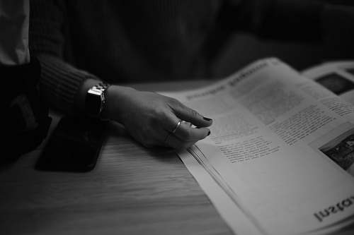 human grayscale photo of a person's hand book
