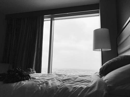 bedroom grayscale photo of bed near white table lamp table lamp