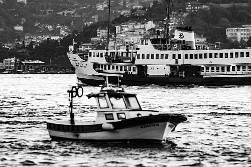 vehicle grayscale photo of boat and cruise ship on body of water person