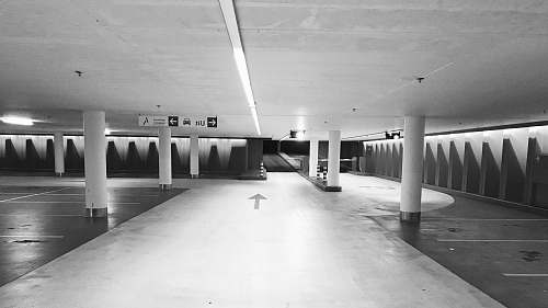 white grayscale photo of building parking lot architecture