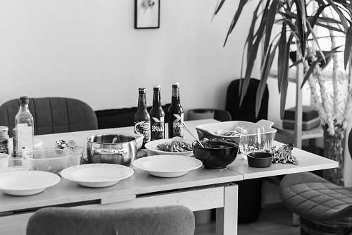 furniture grayscale photo of dining table with plates and bowls dining table