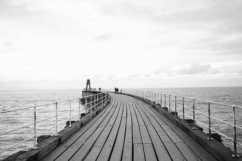 water grayscale photo of dock pier