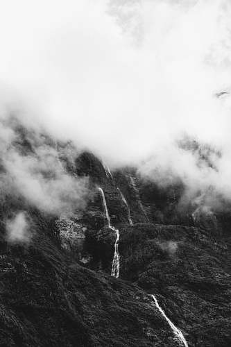 nature grayscale photo of hill covered with mist weather
