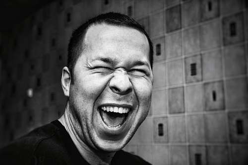 person grayscale photo of man making silly face face