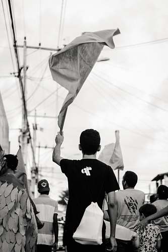 human grayscale photo of man waving a towel person