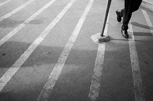 grey grayscale photo of man wearing lace-up shoe leisure activities