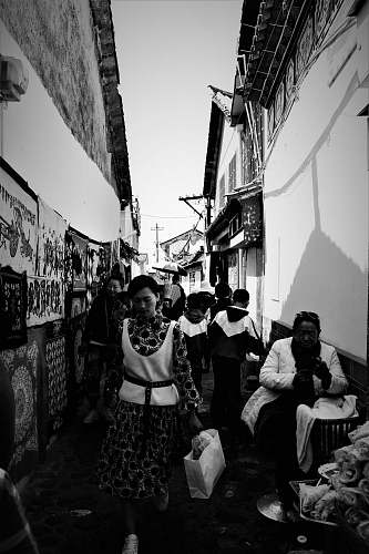 human grayscale photo of people near houses person
