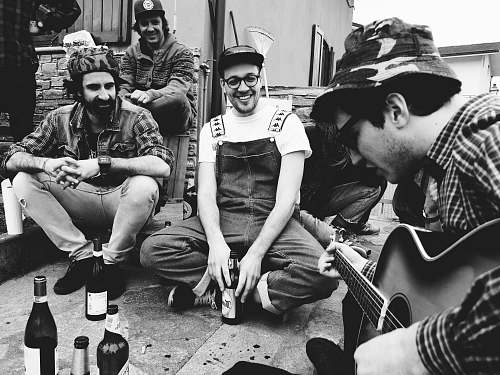 people grayscale photo of people singing while drinking human