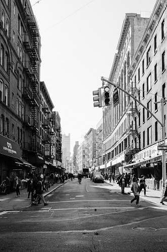 human grayscale photo of people walking on sidewalk pedestrian
