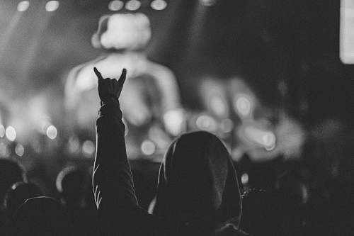 grey grayscale photo of person in hoodie top watching a concert rock am ring