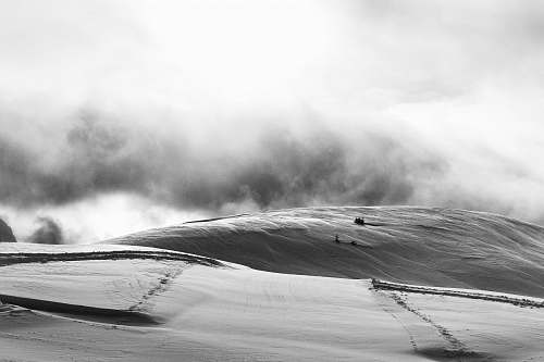 italy grayscale photo of sandstorm in desert passo rolle