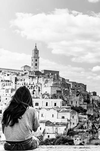 building grayscale photo of woman looking at cathedral human
