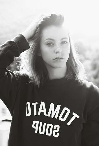 people grayscale photo of woman wearing sweatshirt holding her hair human