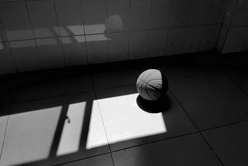 sphere grayscale photography of a basketball on the floor floor
