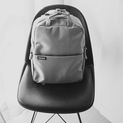 bag grayscale photography of backpack on chair backpack