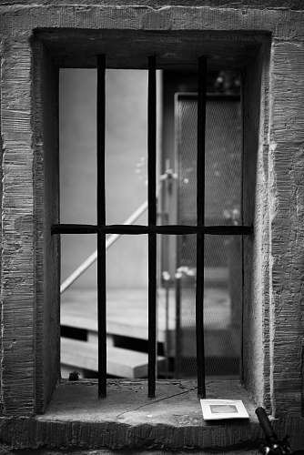 brick grayscale photography of black metal window window