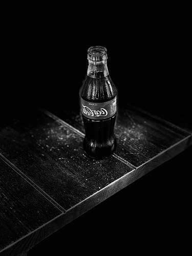 drink grayscale photography of Coca-Cola bottle on table coke