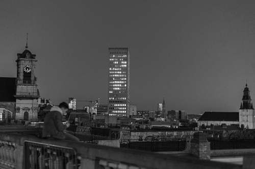 human grayscale photography of concrete buildings person