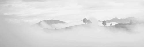 alps grayscale photography of foggy mountain mountain