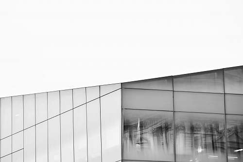 grey grayscale photography of glass building window reflection