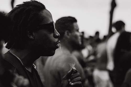 human grayscale photography of man holding cigarette people