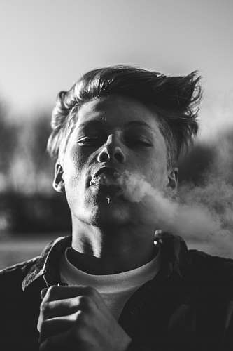 portrait grayscale photography of man in jacket holding box mod man
