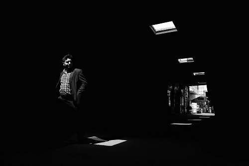 human grayscale photography of man walkning in room person