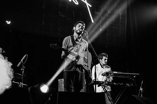 person grayscale photography of men performing on stage music