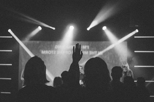 grey grayscale photography of people in front of stage lighting