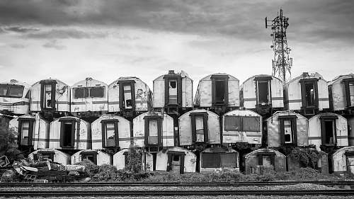 train grayscale photography of piling of container vans carriage