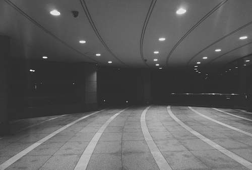 lighting grayscale photography of road tunnel grey