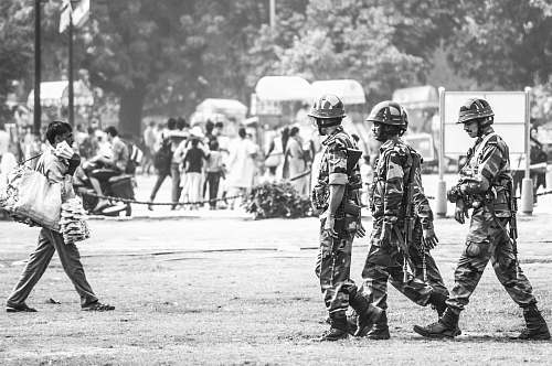 person grayscale photography of three soldiers walking human
