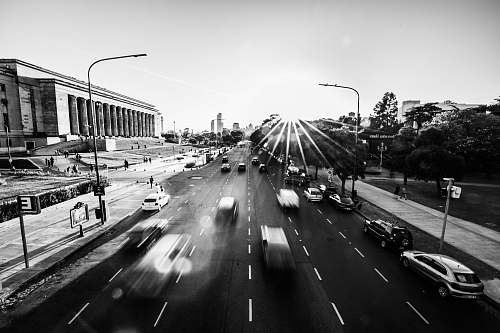 road grayscale photography of vehicles passing by on road automobile