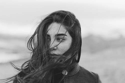 human grayscale photography of woman covered her face with hair face