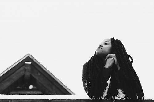 apparel grayscale photography of woman leaning on wood clothing