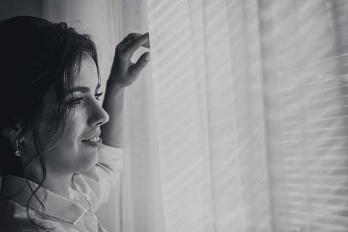grey grayscale photography of woman near window human