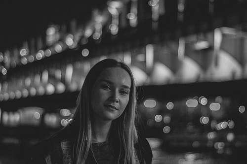 human grayscale photography of woman wearing crew-neck shirt smiling person